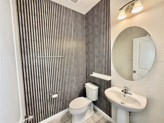 a kitchen with stainless steel appliances kitchen island granite countertop a refrigerator and a sink