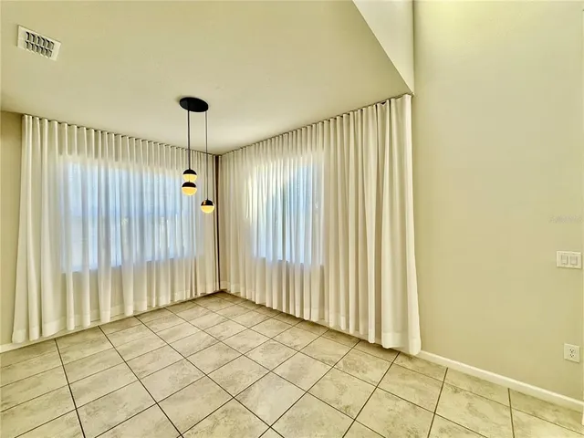 a large white kitchen with a large counter top stainless steel appliances and cabinets