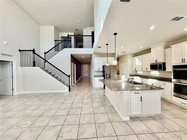a view of an empty room with window and ceiling fan