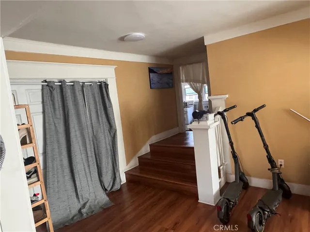 a view of a hallway with wooden floor and stairs