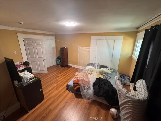 a bedroom with a bed and wooden floor