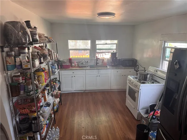 a kitchen with a sink cabinets and wooden floor