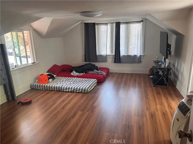 a hallway with a bed and wooden floor