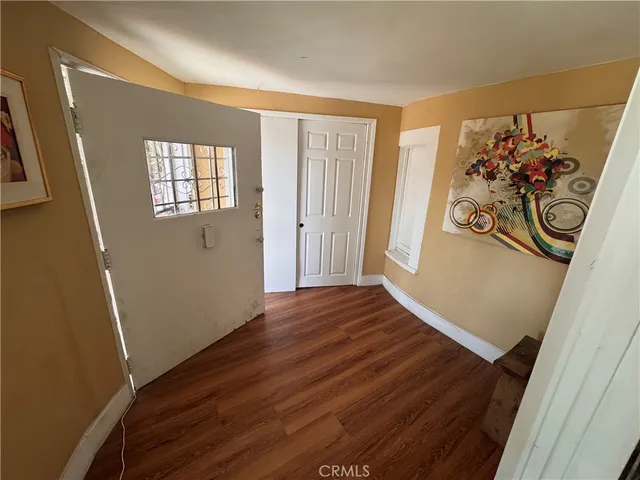 an empty room with wooden floor and window