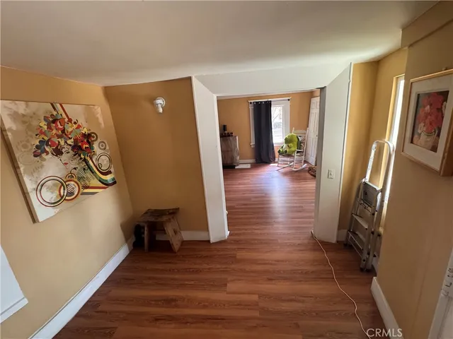 a view of a hallway with wooden floor and furniture