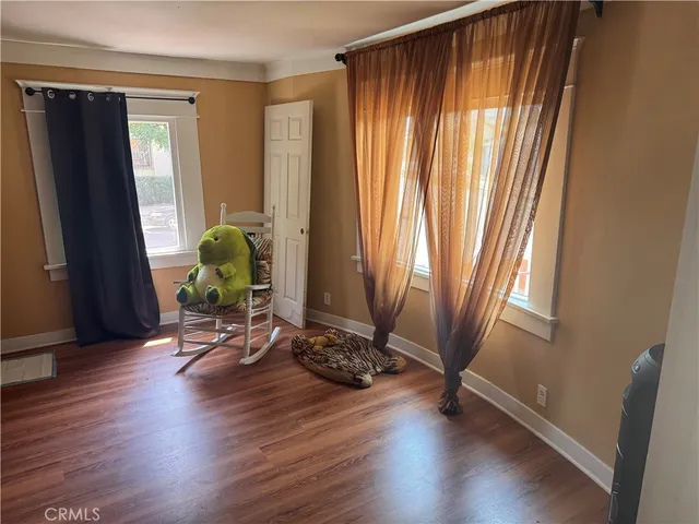 a view of a room with wooden floor and a window