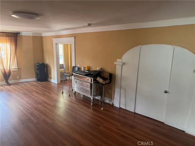 a living room with wooden floor and furniture