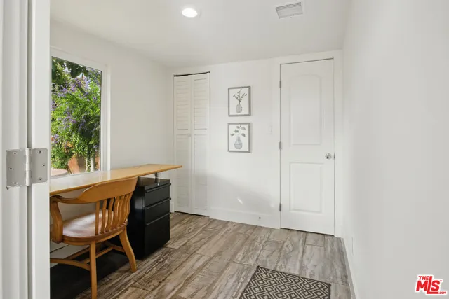 a workspace room with wooden floor and windows