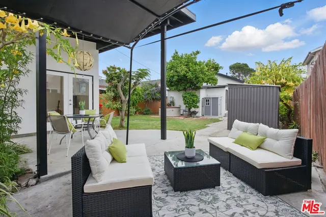 a view of a patio with couches table and chairs and potted plants