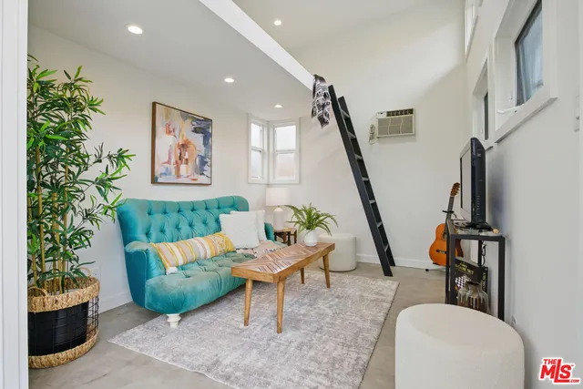 a living room with furniture flowerpot and a flat screen tv