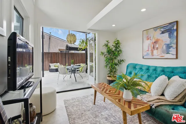 a view of a small house with potted plants and big trees