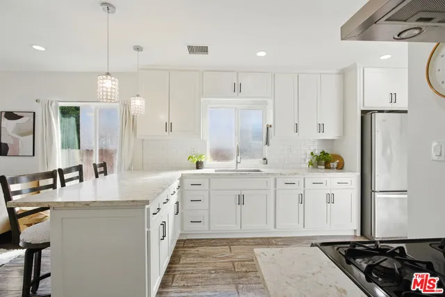 a kitchen with white cabinets and refrigerator