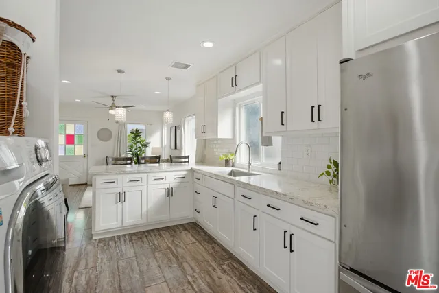 a kitchen with white cabinets appliances and sink