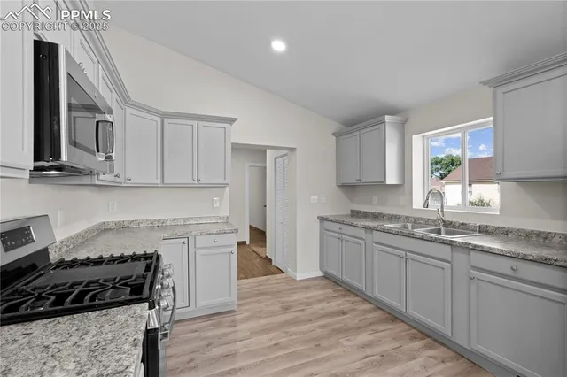 a kitchen with stainless steel appliances granite countertop a stove a sink and a refrigerator