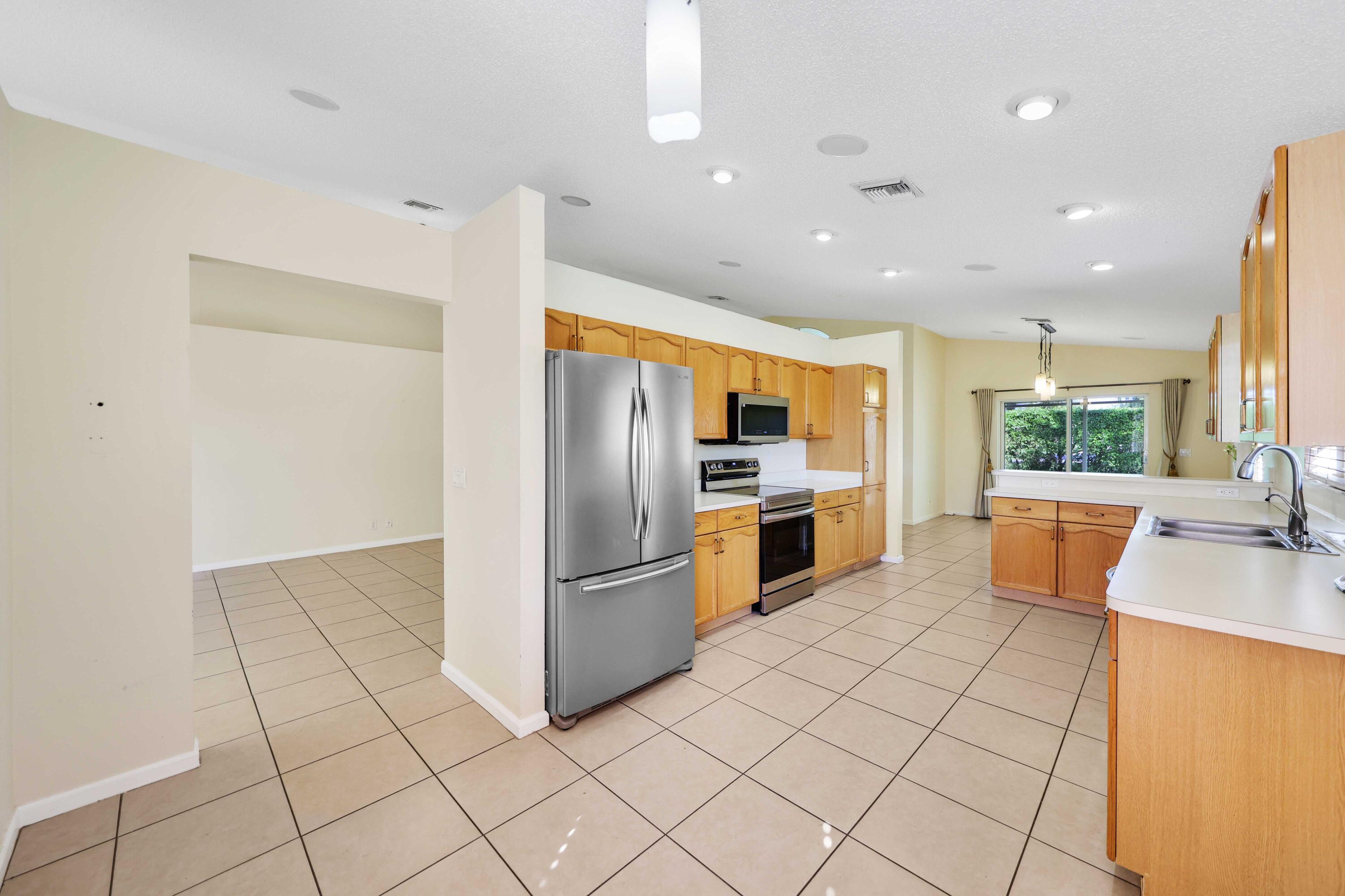 5125 Columbo Court Delray Beach, FL 33484 - Photo 19 of 60 a kitchen with stainless steel appliances a refrigerator sink and stove