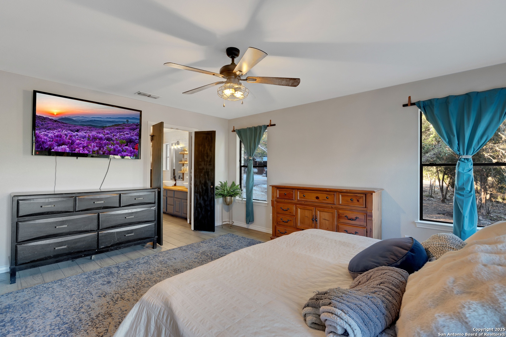 2665 Casey Road Bulverde, TX 78163 - Photo 29 of 42 a bedroom with a bed dresser and a flat screen tv