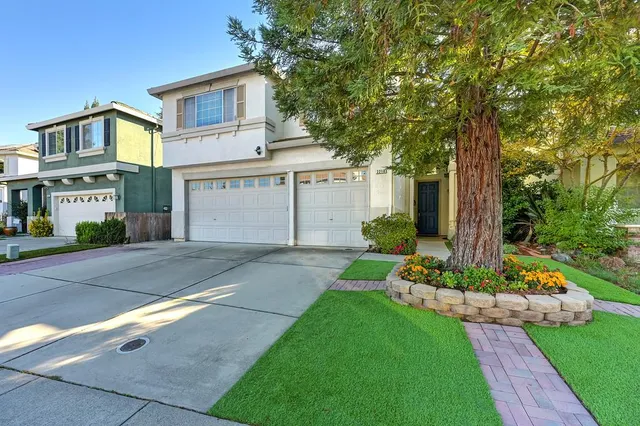 a front view of a house with a yard and garage