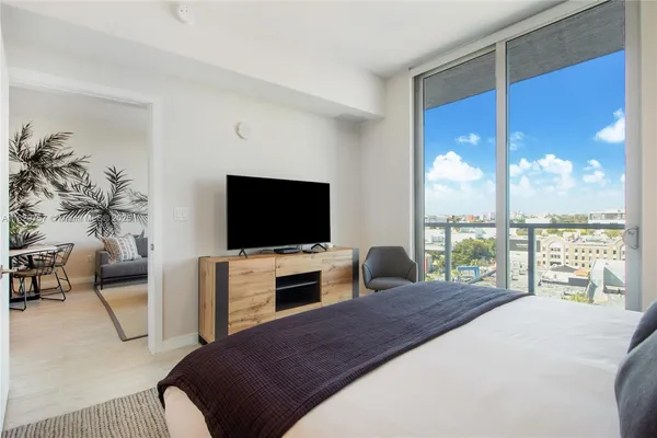 a bedroom with a large bed and a flat screen tv