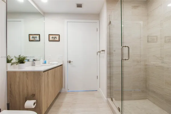a bathroom with a sink a shower and a mirror