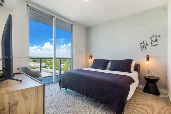 a bedroom with a bed and large window