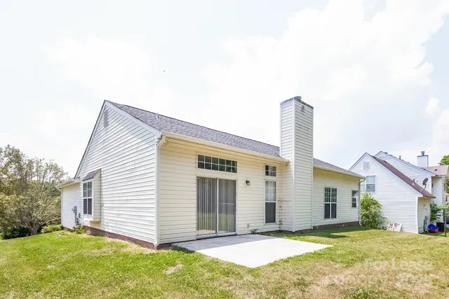 a view of a house with a yard and pathway
