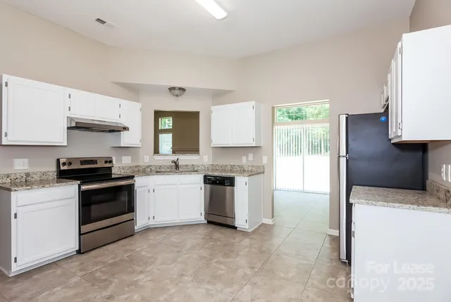 a kitchen with a stove a sink and a refrigerator