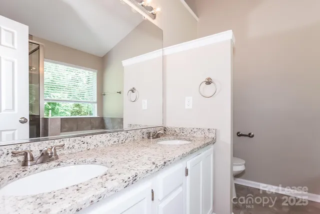 a bathroom with a granite countertop sink a large mirror and a window