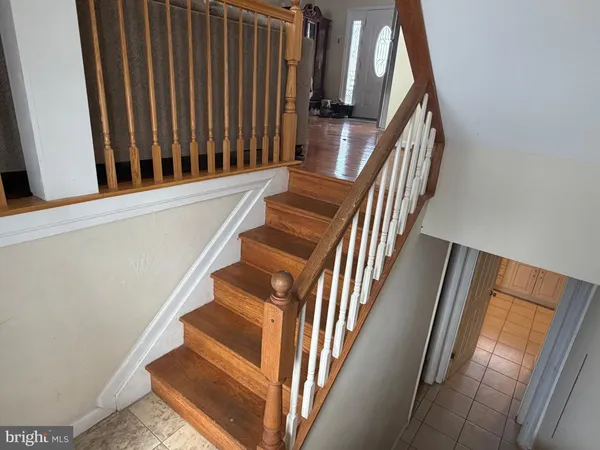 a view of staircase with wooden floor and white walls