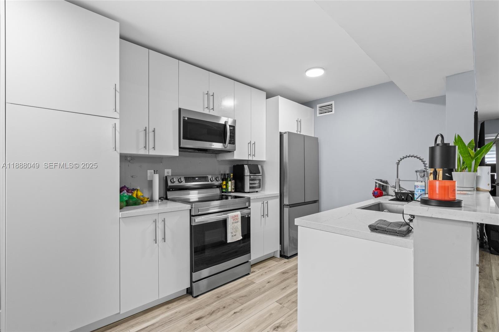 4624 Northwest 97th Place, Unit 252 Doral, FL 33178 - Photo 12 of 28 a kitchen with stainless steel appliances a stove refrigerator sink and microwave