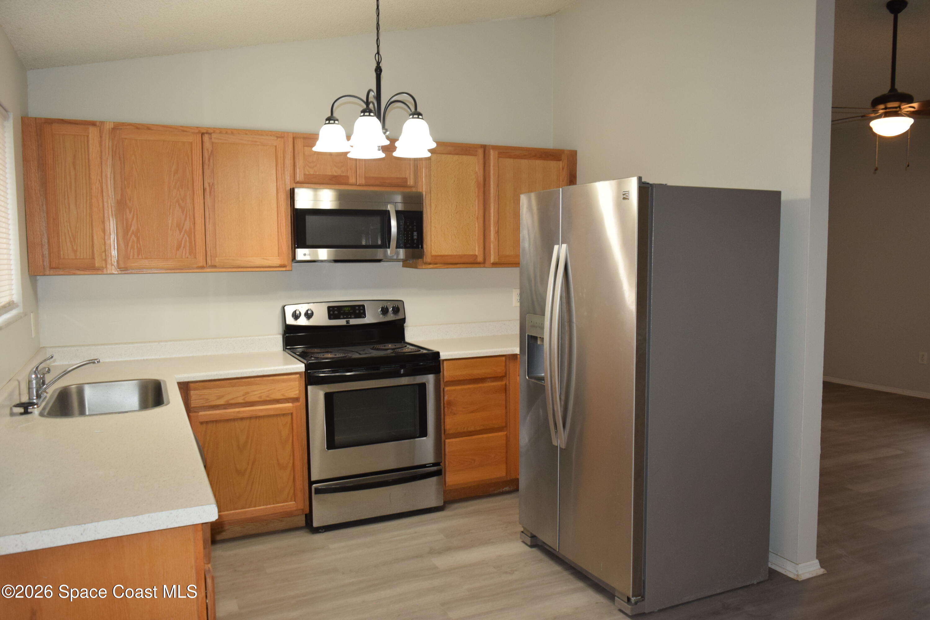213 Abello Road Southeast Palm Bay, FL 32909 - Photo 11 of 23 a kitchen with refrigerator and microwave