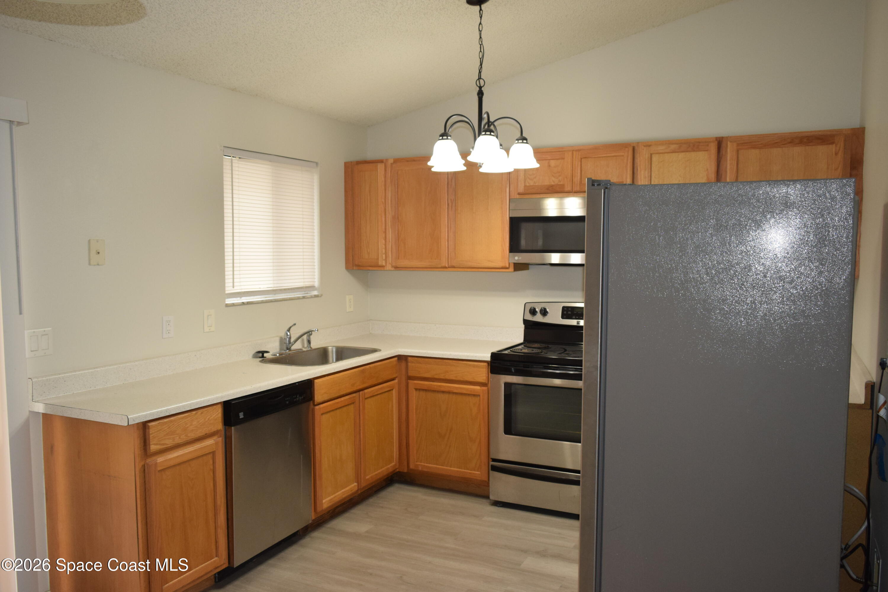 213 Abello Road Southeast Palm Bay, FL 32909 - Photo 9 of 23 a kitchen with stainless steel appliances a sink a refrigerator and cabinets
