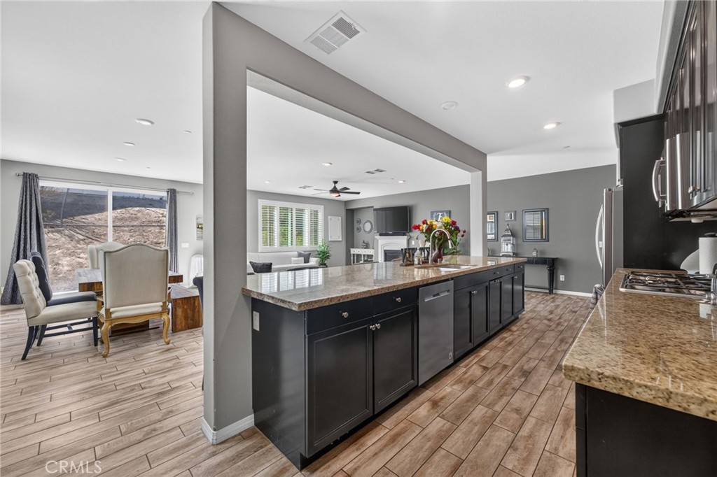 23347 Crystal Way Wildomar, CA 92595 - Photo 21 of 109 a large kitchen with kitchen island granite countertop a large counter top and stainless steel appliances