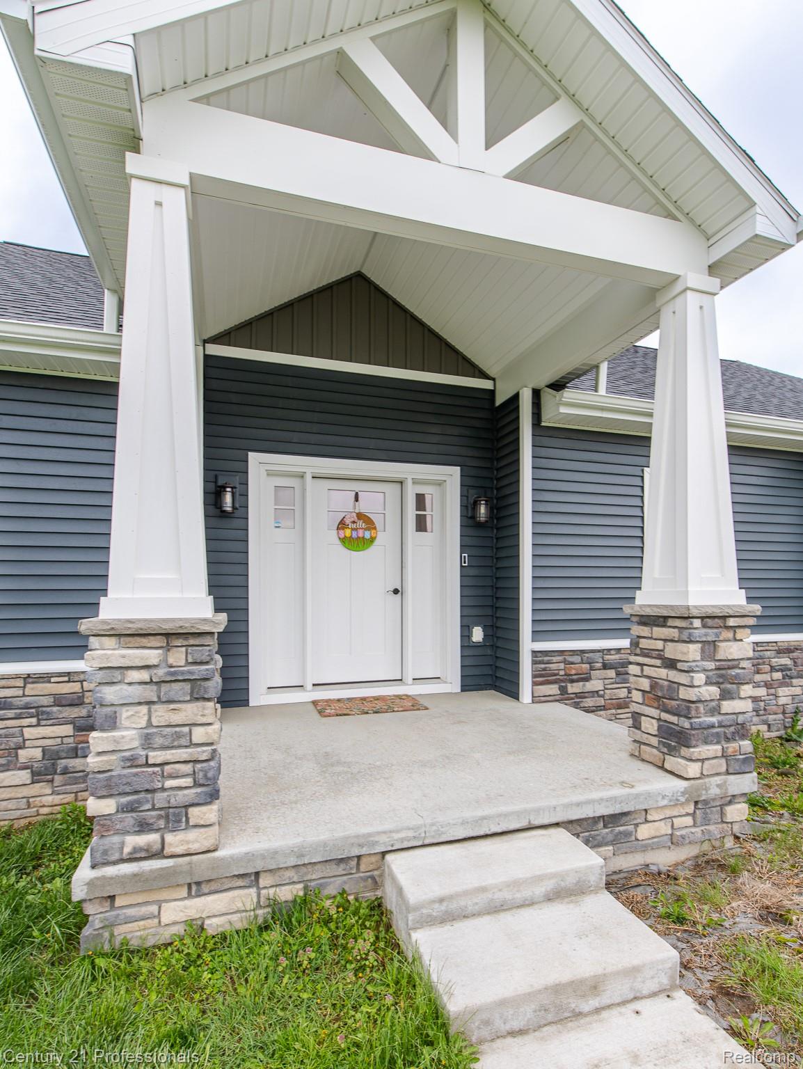 4914 TORATOLA Lane Howell, MI 48843 - Photo 6 of 39 Property entrance featuring a shingled roof, stone siding, and covered porch