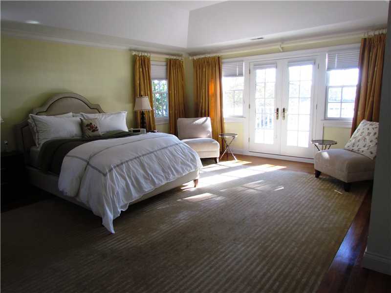 115 Long Neck Point Road Darien, CT 06820 - Photo 14 of 21 a bedroom with a bed and glass walk in closet