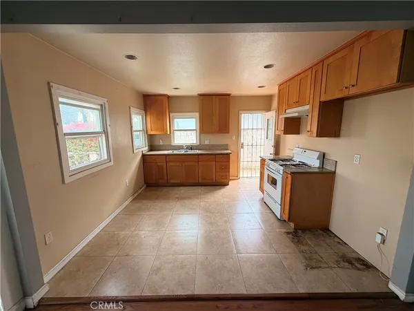 a kitchen with stainless steel appliances granite countertop a refrigerator a stove top oven a sink and dishwasher