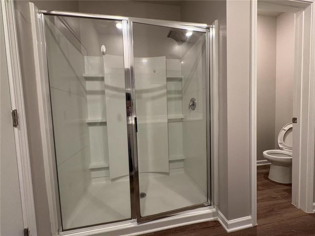 169 Wynn Way Pendergrass, GA 30567 - Photo 15 of 25 a bathroom with a glass door shower and a toilet