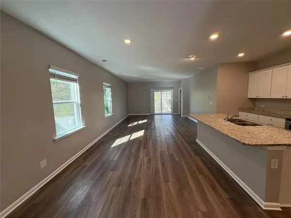 a view of a kitchen with kitchen island wooden floor center island and windows