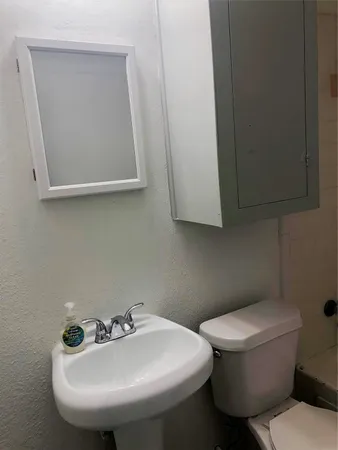 a bathroom with a toilet sink and mirror
