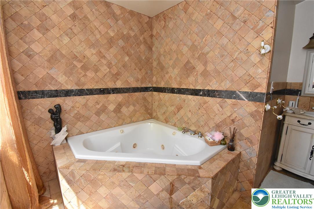 424 Grape Street Whitehall, PA 18052 - Photo 40 of 56 This primary bathroom offers a large jet soaking tub surrounded by elegant tile work.