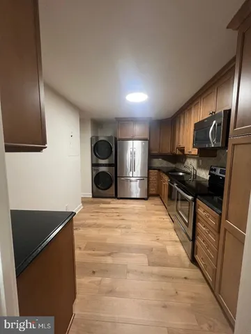 a kitchen with granite countertop stainless steel appliances a refrigerator sink and microwave