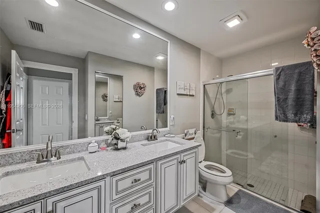a bathroom with a granite countertop sink toilet and shower