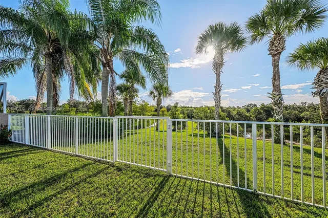 a view of a swimming pool with a garden and palm trees