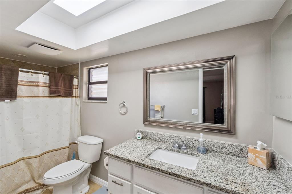 4608 Frisco Circle Orlando, FL 32808 - Photo 18 of 26 a bathroom with a granite countertop sink mirror vanity and toilet