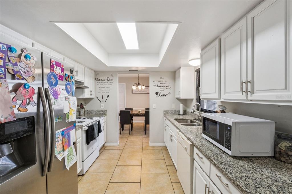 4608 Frisco Circle Orlando, FL 32808 - Photo 9 of 26 a kitchen with stainless steel appliances granite countertop a stove a sink and a refrigerator