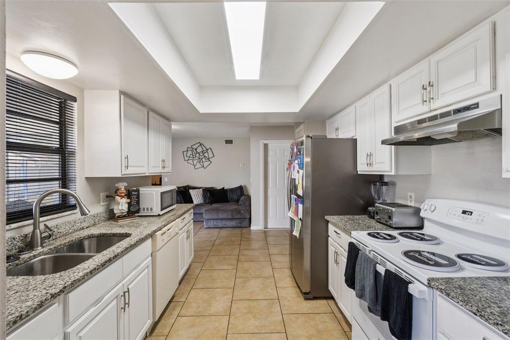 4608 Frisco Circle Orlando, FL 32808 - Photo 10 of 26 a kitchen with stainless steel appliances granite countertop a sink stove and refrigerator