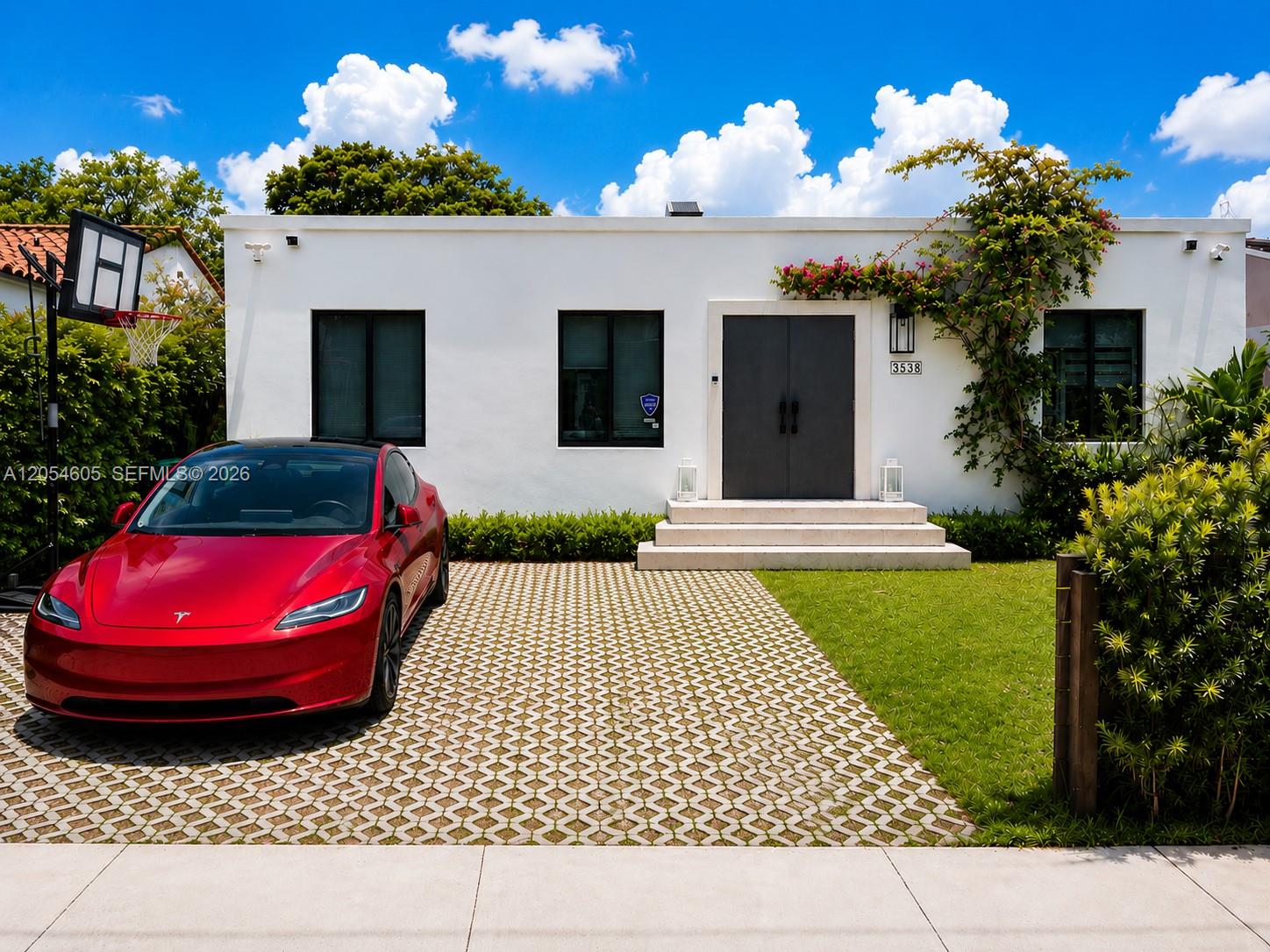 3538 Southwest 1st Avenue, Unit 1 Miami, FL 33145 - Photo 1 of 20 Beautifully renovated contemporary residence featuring a striking modern façade, elegant oversized entry, lush tropical landscaping, and a spacious two-car driveway with EV charging.