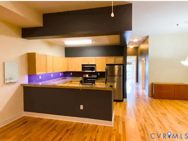 a view of kitchen with stainless steel appliances granite countertop sink and cabinets