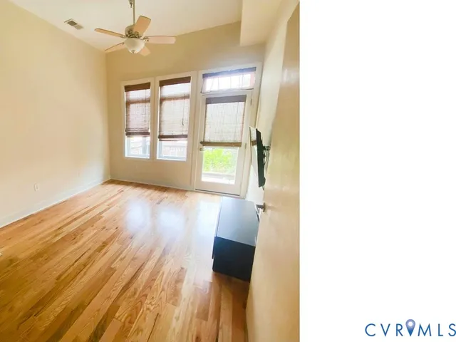a view of hallway with a large window and wooden floor