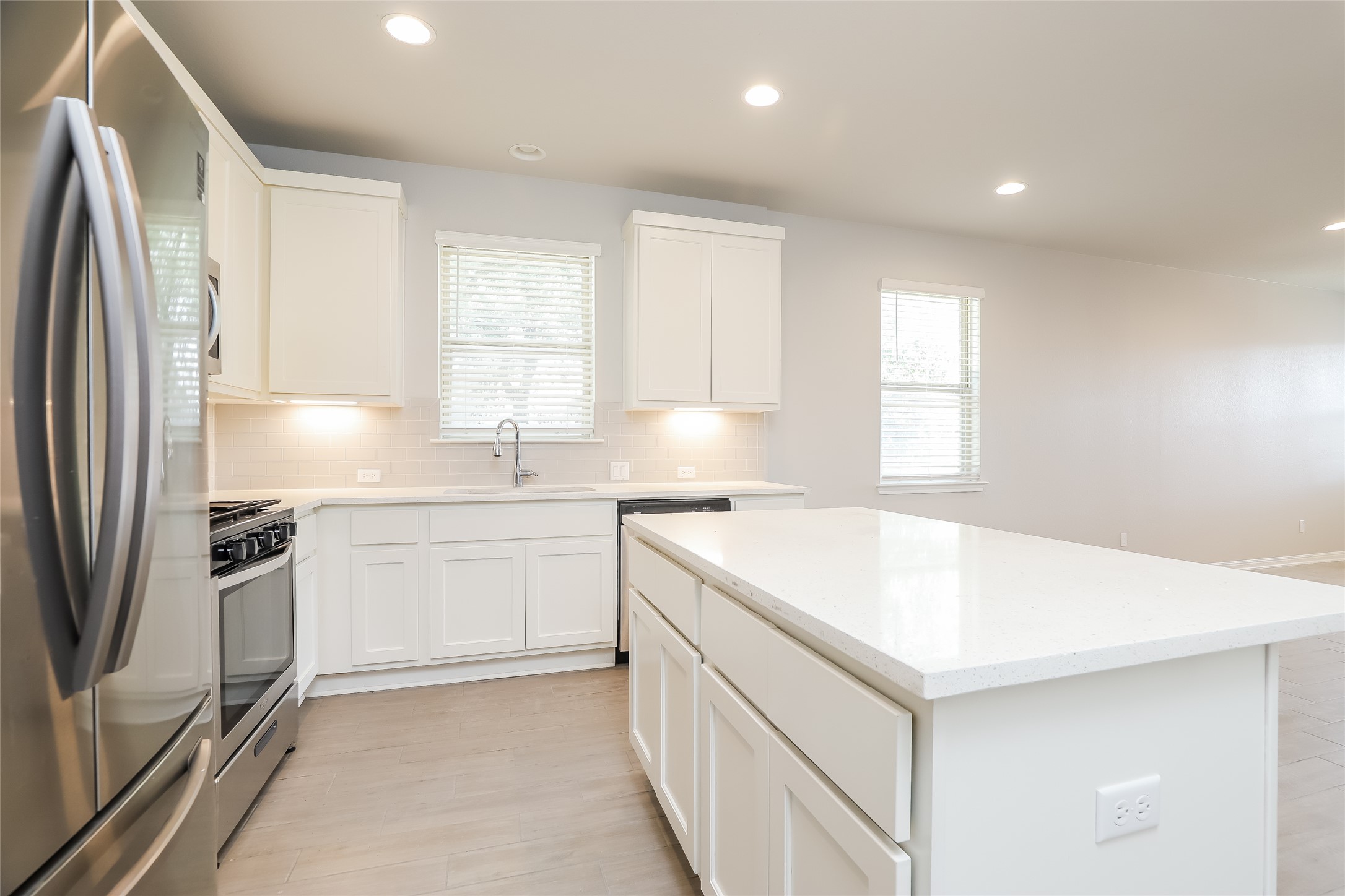 2724 Juniper Woods Road Leander, TX 78641 - Photo 8 of 21 Modern kitchen with sleek white cabinetry, gleaming quartz countertops, and stainless steel appliances.