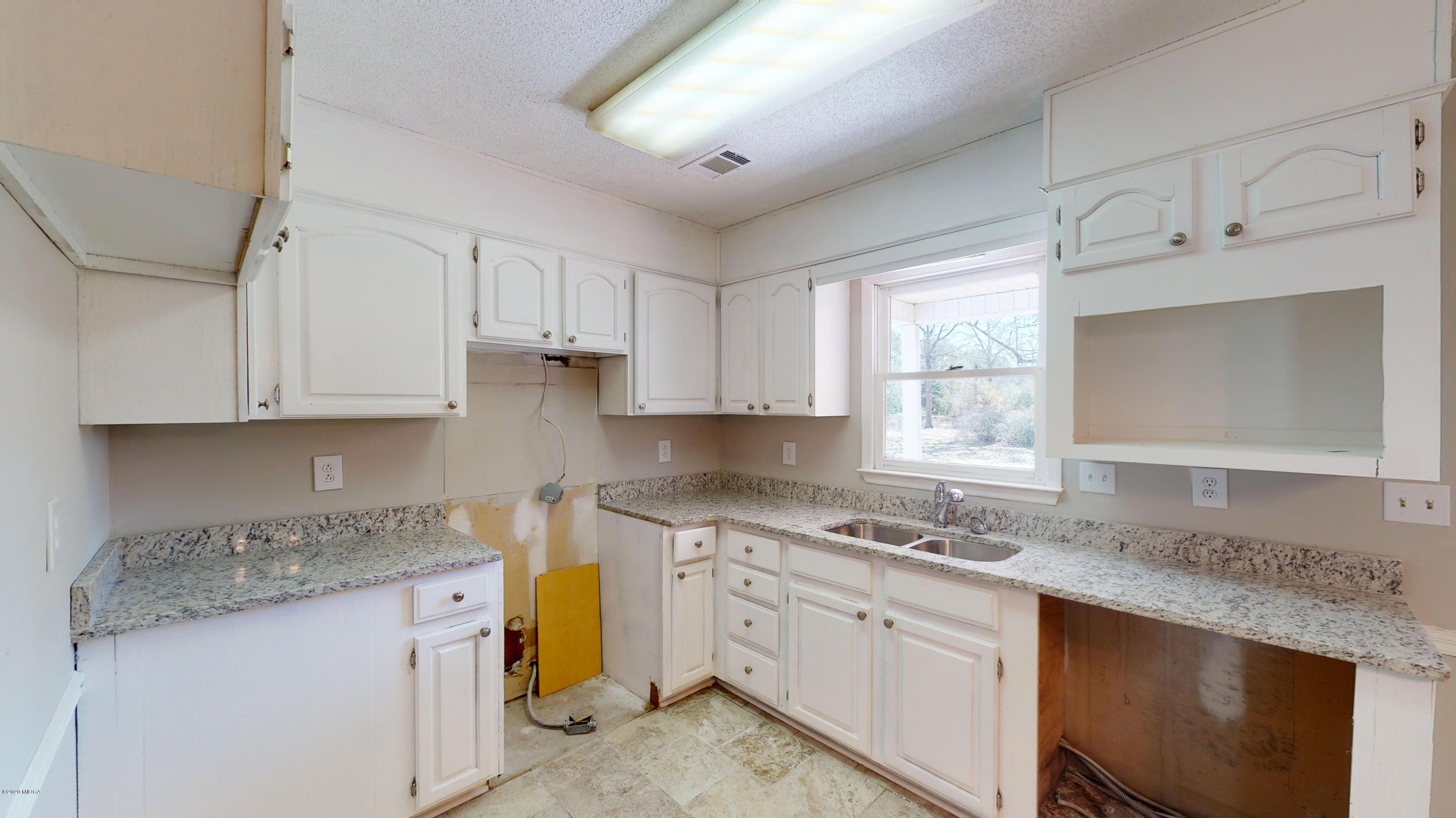 7228 Columbus Road Lizella, GA 31052 - Photo 9 of 41 a kitchen with granite countertop white cabinets white appliances a sink and a window
